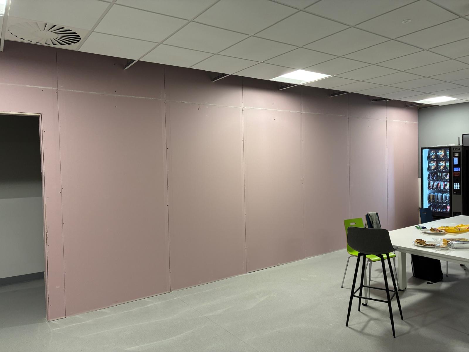Boarded interior partition walls beneath a suspended grid ceiling