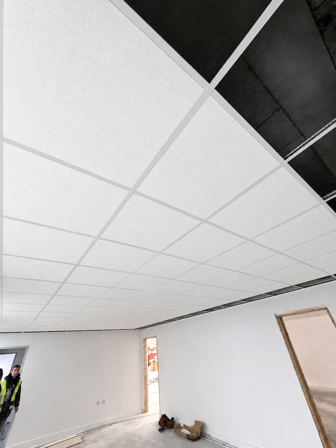 Suspended grid ceiling with ceiling tiles being installed