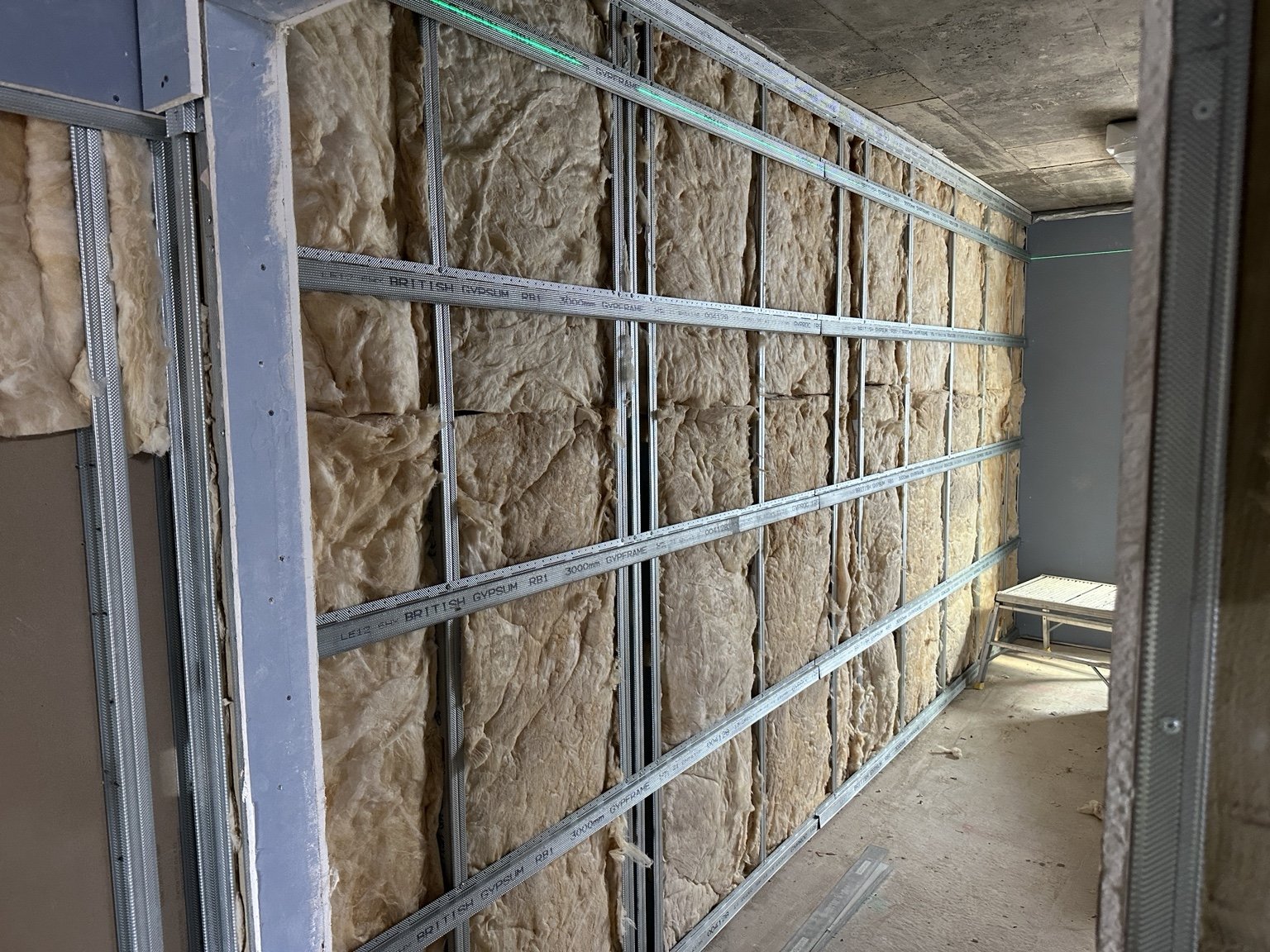 Insulation fitted within metal stud partition framing
