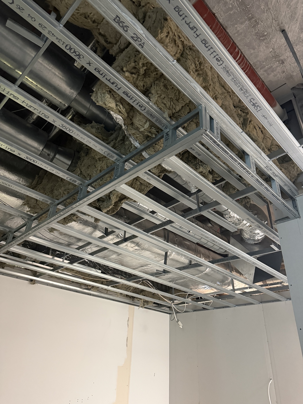 Metal ceiling framework beneath building services